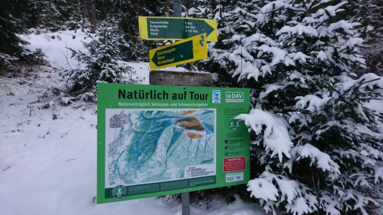 Infotafel am Anfang der Skitour. Skitouren/Schneeschuhläufer-Symbole des DAV markieren die Route.