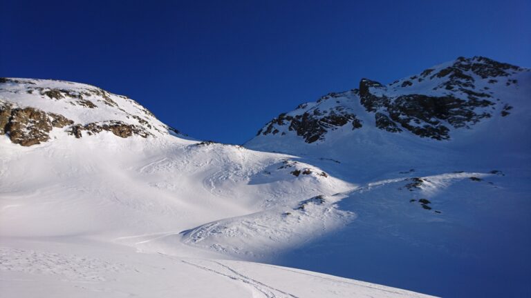 Der Aufstieg erfolgt durch die Mulde zwischen Muot Arduond (links) und Piz Minor (rechts), Schatten-/Lichtgrenze im Bild.